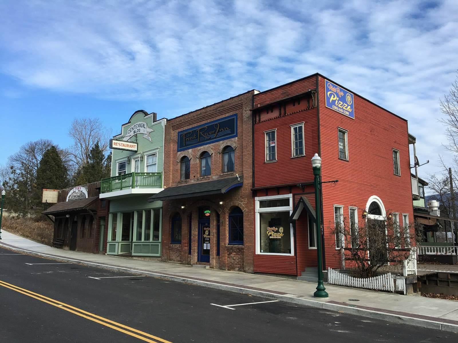 Historic storefronts in downtown Priest River under a blue sky.