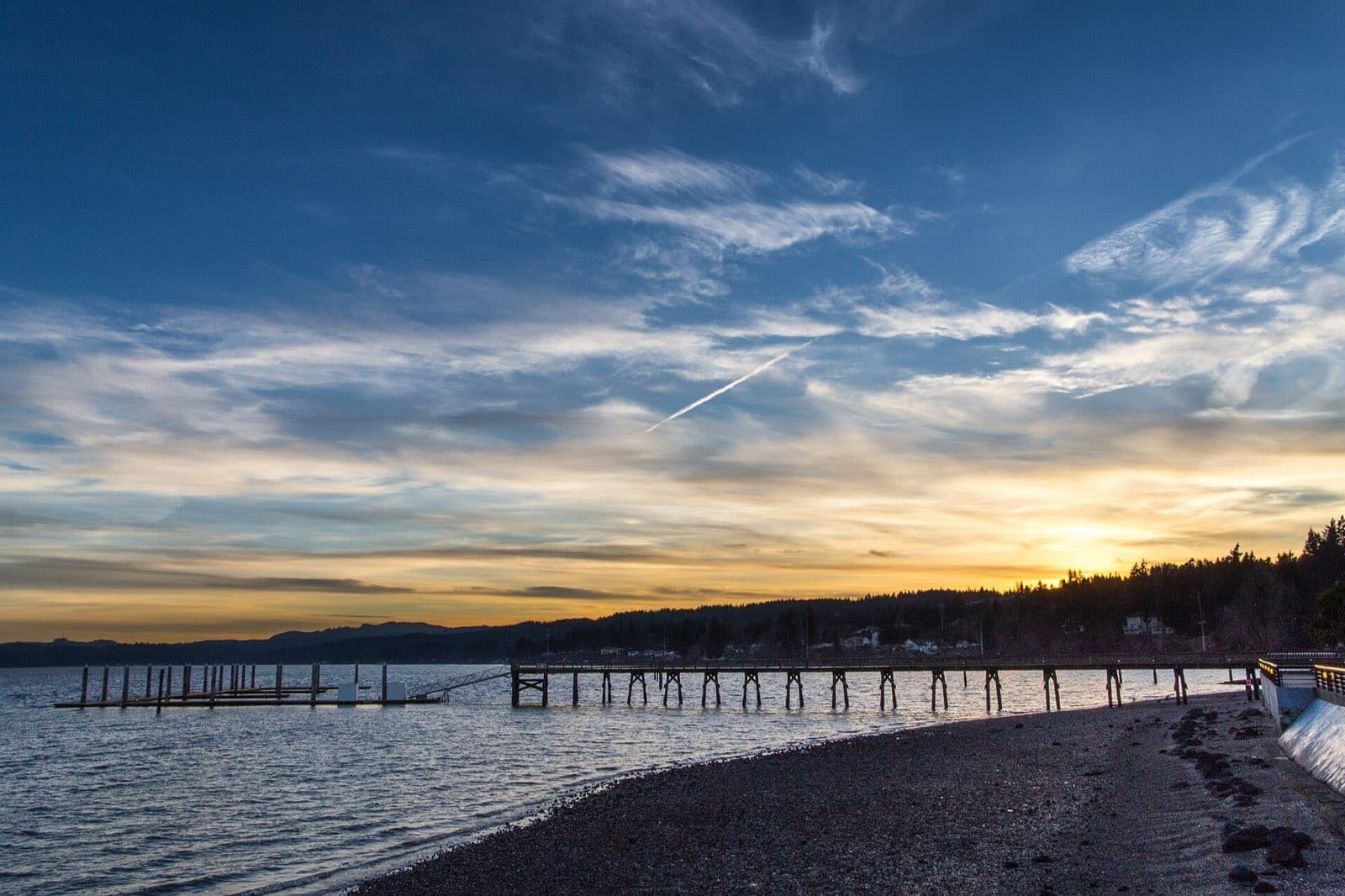 Sunset over Dyes Inlet from the Silverdale waterfront, with the old pier pilings silhouetted on the water.