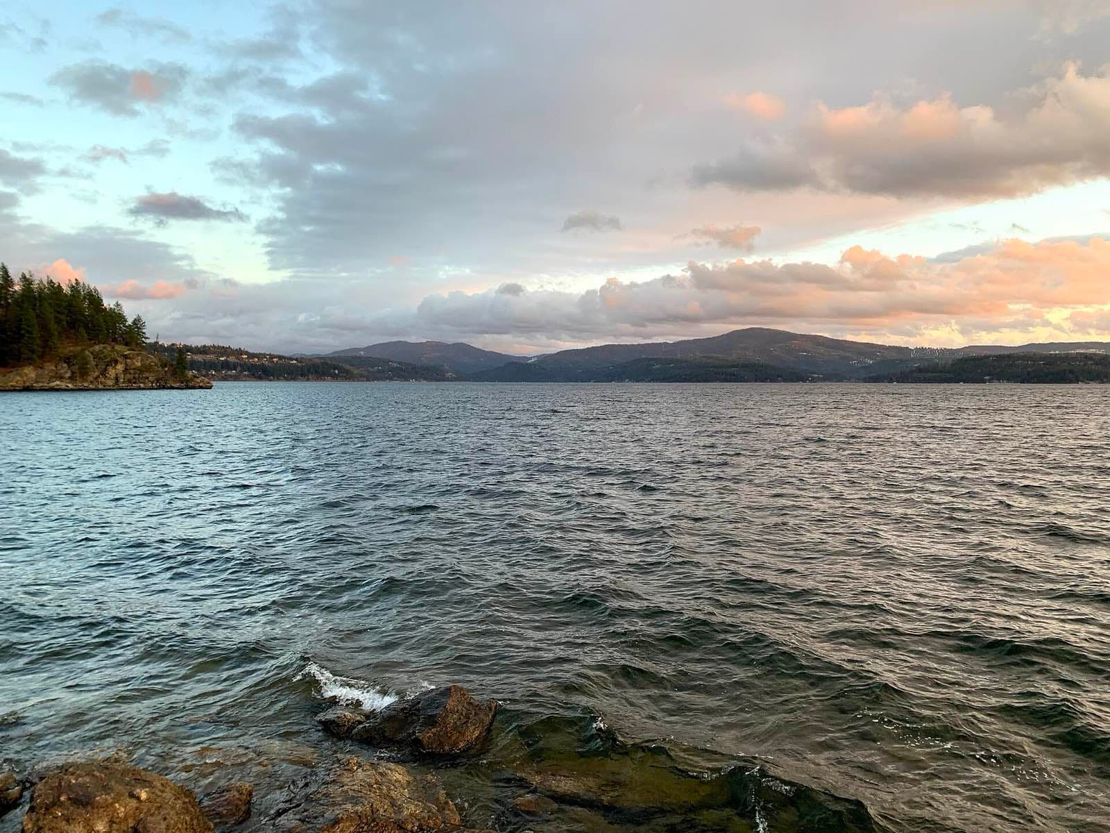 Lake Coeur d'Alene at sunset seen from Tubbs Hill, with hills fading into the distance.